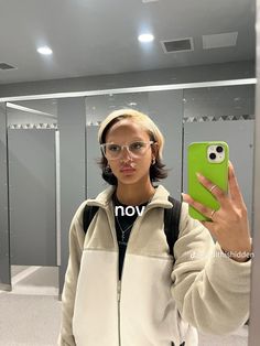 a woman taking a selfie in front of a mirror with an owl phone case