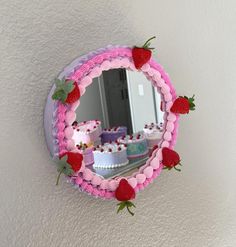 there is a mirror that has strawberries on it and cake in the reflection behind it