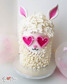 a cake that looks like a llama with heart shaped glasses on it's face