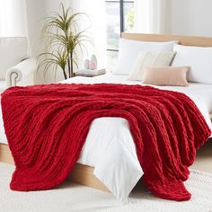 a large red blanket on top of a bed