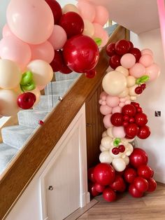 the staircase is decorated with balloons and streamers in shades of red, white, and pink