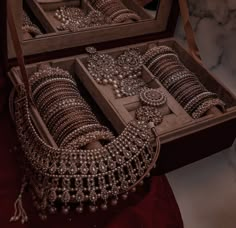 two wooden boxes filled with different types of jewelry