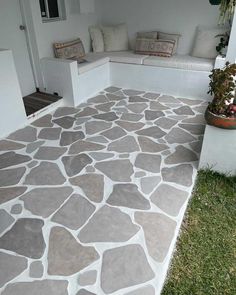 an outdoor patio with stone flooring and potted plants on the side of it