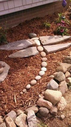 a garden with rocks and flowers around it