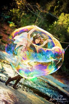 a woman is holding a large bubble in the air