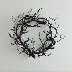 a black wreath with branches and birds on it