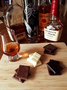 some chocolates and liquor are sitting on a cutting board