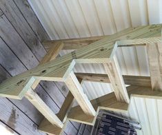 three wooden shelves hanging from the side of a building with wood boards attached to them