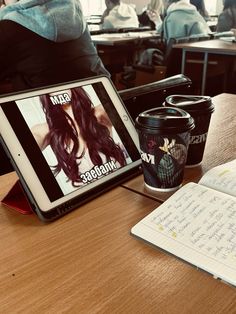 a tablet computer sitting on top of a wooden table next to a cup of coffee