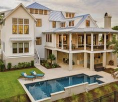 a large white house with a pool in the front yard and two story home on the other side