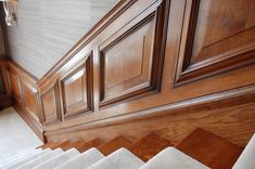 the stairs are lined with wood paneling and carpet