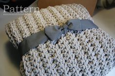 a crocheted blanket with a bow on it