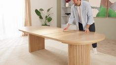 a man standing in front of a wooden table