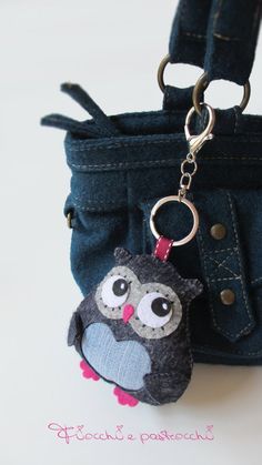 an owl keychain hanging from a blue purse