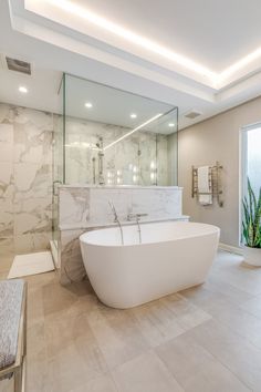 a large white bath tub sitting inside of a bathroom next to a walk in shower