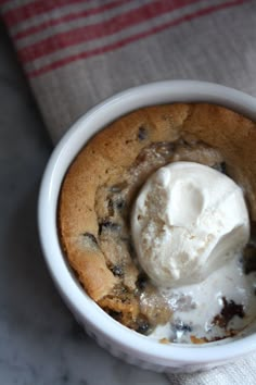 a close up of a dessert in a bowl with ice cream on top and chocolate chips