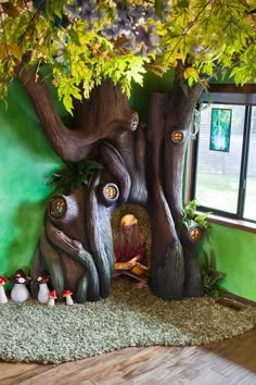 an indoor play area with fake trees and gnomes in the background, including a window