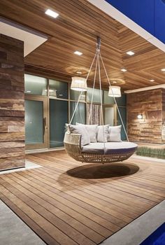 an image of a porch with a swing chair on the deck and lights above it