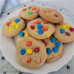 a white plate topped with cookies covered in m & m candies and chocolate chips