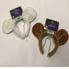 two baby headbands with ears and ear tags on them, one brown and the other white