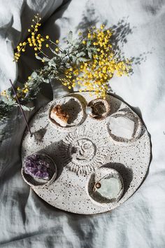 an arrangement of rocks and flowers on a tray