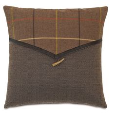 a brown and black pillow with an envelope on it