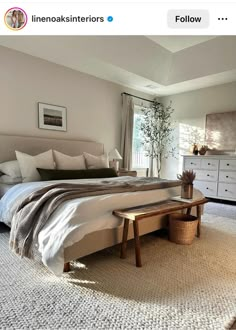 a bedroom with a large bed, dresser and window in it's center area