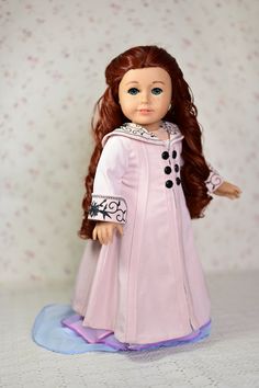 a doll with red hair wearing a pink dress