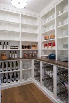 a pantry with lots of bottles and dishes on the shelves, including wine glasses in baskets