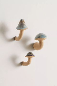 three small ceramic mushrooms on a white surface