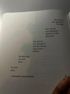 someone is holding an open book with the words autumn captions on it and there are two hands