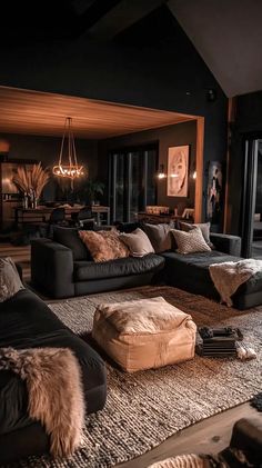 a living room filled with black furniture and lots of pillows on top of the floor