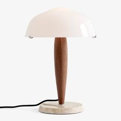 a wooden lamp with a white shade on it's base and a black cord