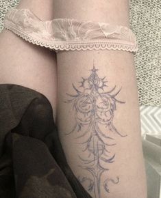 a woman's leg with a tattoo on it and lace around the ankle strap