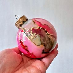 Choose from these glamorous Hand-Painted Christmas Ornaments in Magenta Pink and Gold - a stunning and opulent addition to your holiday decor. These exquisite ornaments bring a touch of regal elegance and vibrancy to your festive display. Exquisite Craftsmanship: Each ornament is meticulously hand-painted, including the process of painting the colors inside the ornament and hand-drawing the gold highlights on the exterior ensuring every detail is captured with precision and care. The intricate detailing and rich color palette of magenta pink and gold combine to create a breathtaking and luxurious finish. Regal Elegance: The vibrant magenta pink is reminiscent of royalty and luxury, while the shimmering gold accents add a touch of opulence. Together, they infuse your holiday decor with an a Ink Ornaments, Craft Watch, Holiday Crafts Decorations, Regal Elegance, Homemade Ornaments, Painted Christmas Ornaments, 2024 Christmas