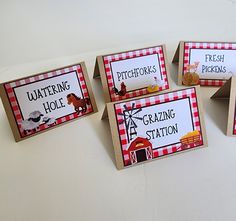 four place cards with pictures of farm animals on them and the words grazing station in red and white