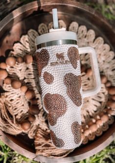 a coffee cup sitting on top of a wooden bowl filled with nuts and other things