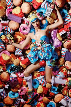 a woman laying on top of a pile of stuffed animals