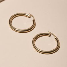 Medium Hollow Hoop Earrings Minimalist Polished Finish Hoop Earrings For Everyday Luxury, Everyday Round Huggie Earrings In Recycled Gold, Classic Single Small Hoop Earring, Minimalist 14k Gold Huggie Earrings With Shiny Finish, Classic Small Hoop Hypoallergenic Jewelry, Hypoallergenic Small Hoop Classic Jewelry, Classic Hypoallergenic Small Hoop Jewelry, Minimalist Round Huggie Earrings, Timeless Round Hoop Earrings For Everyday Elegance