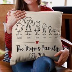 a woman holding a pillow with family pictures on it and the words, the mom's family est 2013