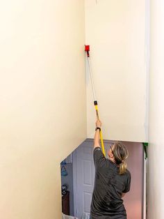 a woman is painting the walls in her home