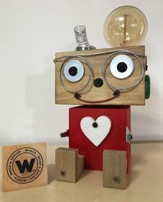 a robot made out of wood with eyes, nose and head on top of blocks