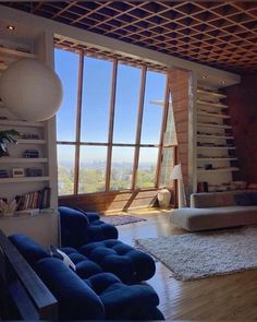 a living room with wooden floors and large windows looking out onto the surrounding cityscape