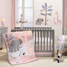 a baby's room with pink walls and grey crib bedding, an elephant wall decal, and other nursery decor