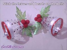 two bells with holly leaves and beads on them