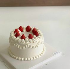 a small white cake with strawberries on top