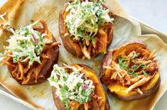 four stuffed sweet potatoes topped with coleslaw and garnish on a plate