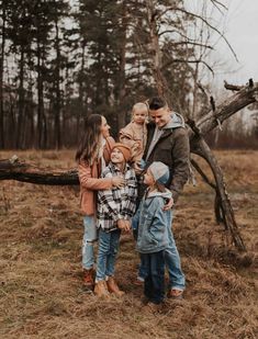 a family standing in front of a fallen tree during an outdoor photo session at the park