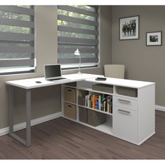 a computer desk with a laptop and bookshelf in front of it on top of a hard wood floor