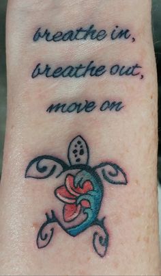 a small turtle tattoo on the wrist saying breathe in, breathe out, move on